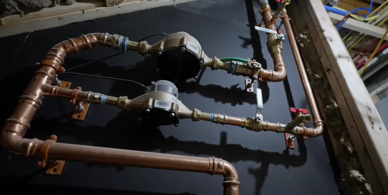 A neat installation of gas meters mounted on an exterior wall in an urban setting.